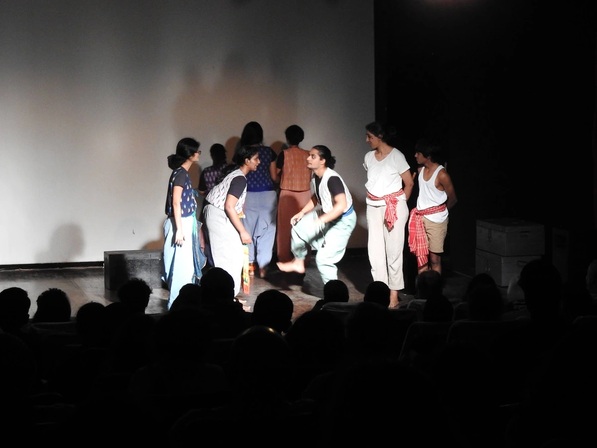 I lift one knee in an animated exchange with the ensemble on stage
