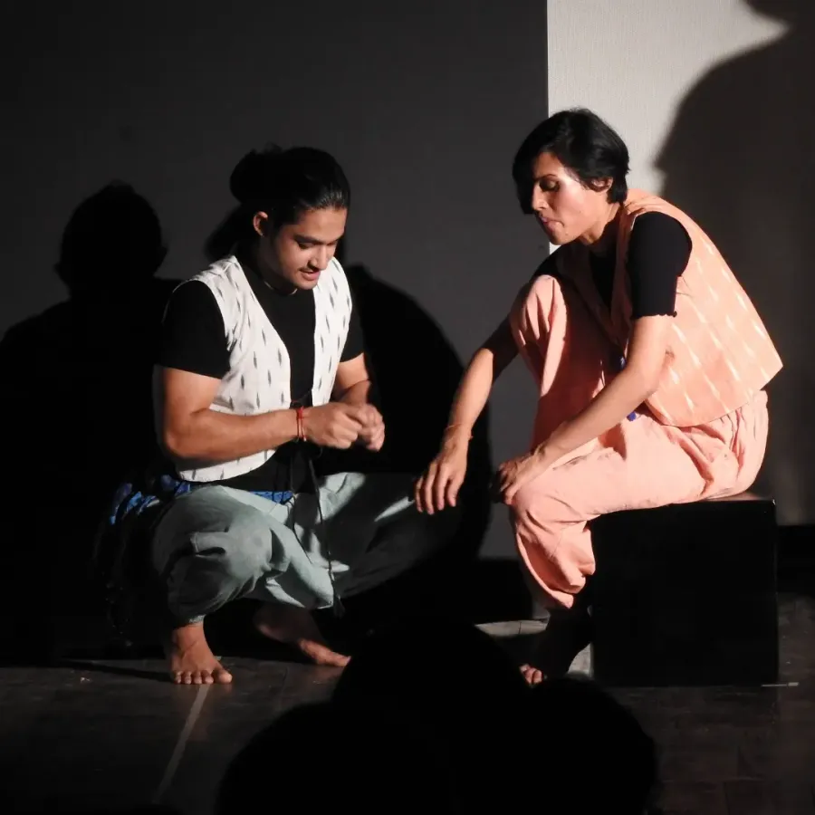 Saran and a fellow performer seated on stage in Beyond the Land of Hattamala